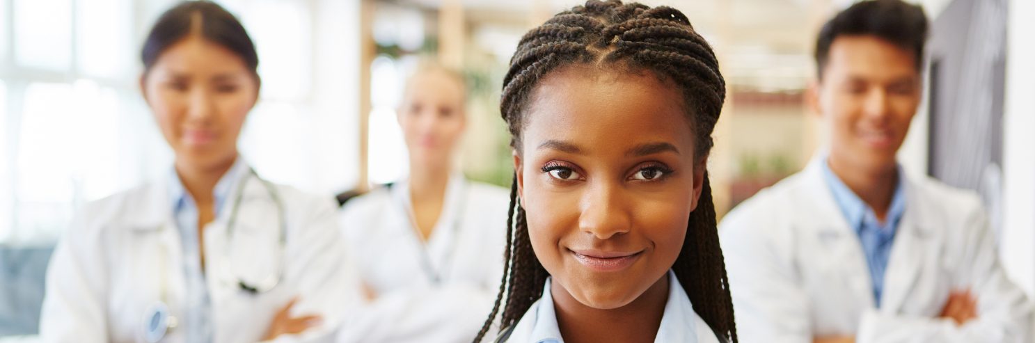 Medical technologist standing with a team of clinicians in a healthcare facility