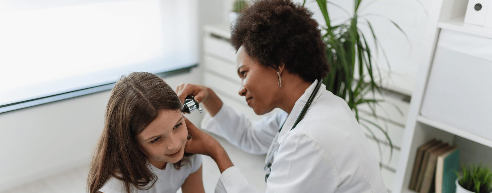 Healthcare technician examining a patient with a diagnostic instrument